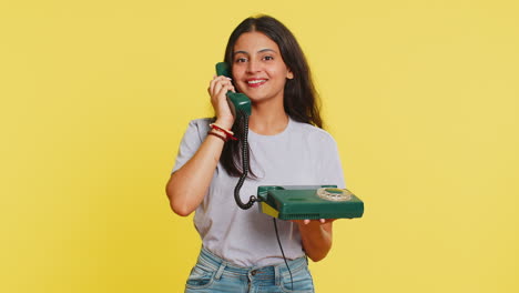 Indian-woman-talking-on-wired-landline-vintage-telephone,-advertising-proposition-of-conversation