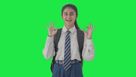 Happy-Indian-school-girl-showing-okay-sign-Green-screen