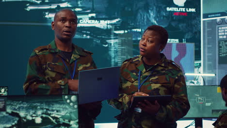 Sergeant-major-and-female-soldier-checking-real-time-field-data-in-command-post