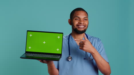 Portrait-of-male-nurse-showing-medical-instructions-video-on-green-screen-tablet