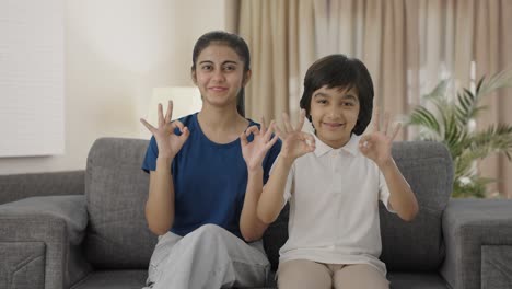 Happy-Indian-siblings-showing-okay-sign-to-the-camera