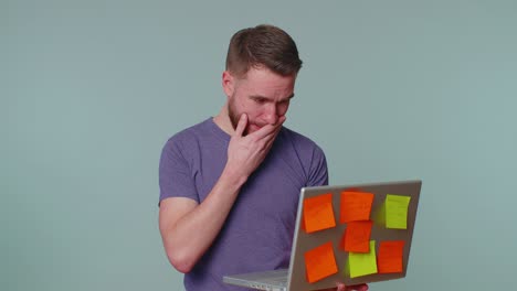 Exhausted-man-freelancer-with-pasted-sticker-notes-using-laptop-computer,-concentration-problem