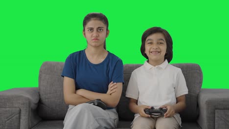 Niño-Indio-Se-Burla-De-Su-Hermana-Después-De-Ganar-La-Pantalla-Verde-De-Un-Videojuego