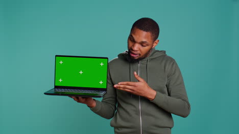 Man-holding-green-screen-laptop,-doing-recommendation