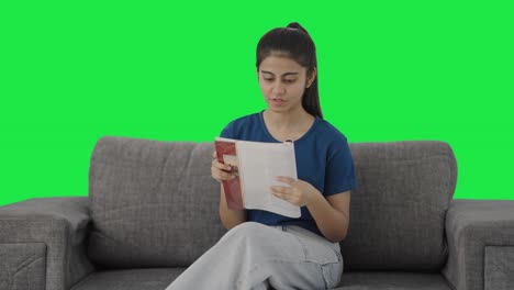 Happy-teenage-Indian-girl-reading-books-Green-screen