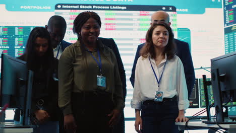 Diverse-group-of-business-professionals-posing-together-in-monitoring-room