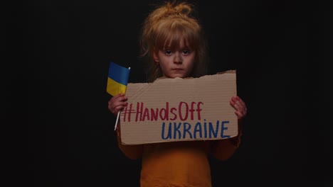 Upset-poor-girl-homeless-protesting-war-conflict-raises-banner-with-inscription-Hands-Off-Ukraine