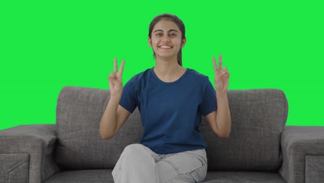 Happy-Indian-teenage-girl-showing-victory-sign-Green-screen