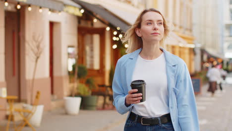 Happy-woman-enjoying-morning-coffee-hot-drink-and-smiling-relaxing,-taking-a-break-on-city-street