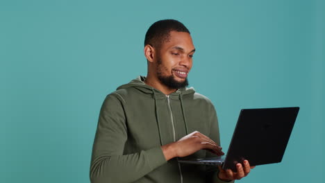 Man-scrolling-on-laptop,-using-internet-and-credit-card-to-pay-for-products