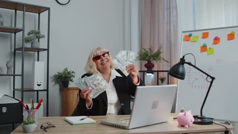 Business-woman-accountant-celebrating-business-success-dancing-with-stack-of-money-dollar-cash