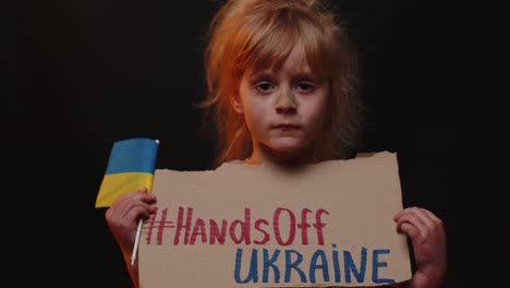 Scared-poor-girl-homeless-protesting-war-conflict-raises-banner-with-inscription-Hands-Off-Ukraine