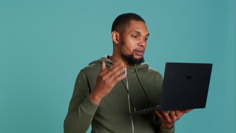 Man-in-teleconference-meeting-with-friends-using-laptop