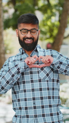 Indian-man-makes-symbol-of-love,-showing-heart-sign-to-camera,-express-romantic-positive-feelings