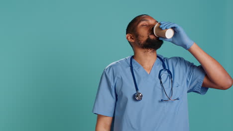 Male-nurse-enjoying-fresh-cup-of-coffee-during-job-shift-break