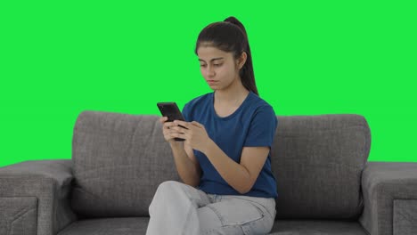 Serious-Indian-teenage-girl-chatting-with-someone-Green-screen