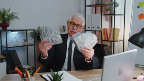 Business-man-accountant-celebrating-business-success-dancing-with-stack-of-money-dollar-cash