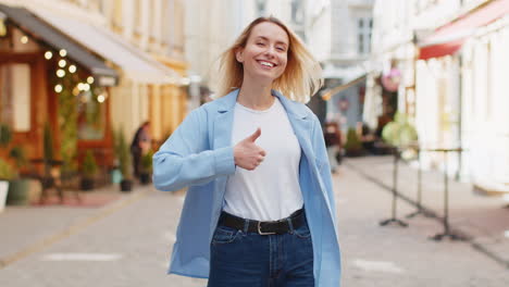 Una-Turista-Feliz-Mostrando-Sus-Pulgares-Hacia-Arriba-Como-Algo-Positivo,-Una-Buena-Retroalimentación-Positiva-En-Las-Calles-De-La-Ciudad