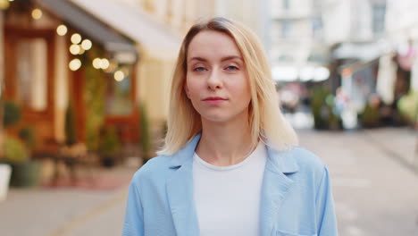 Happy-blonde-woman-smiling-looking-away-dreaming-resting-good-news-feel-satisfied-on-city-street