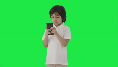 Niño-Indio-Enviando-Mensajes-De-Texto-A-Alguien-En-La-Pantalla-Verde-Del-Teléfono