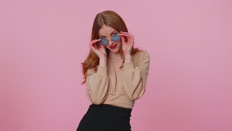 Sincera-Y-Alegre-Chica-Morena-Con-Blusa-Beige-Con-Gafas-De-Sol,-Sonrisa-Encantadora-En-La-Pared-Rosa