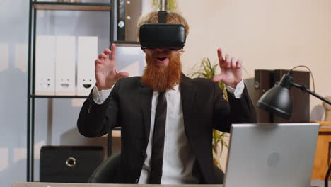 Young-business-man-in-VR-goggles-watch-virtual-reality-video,-working-on-simulation-game-at-office