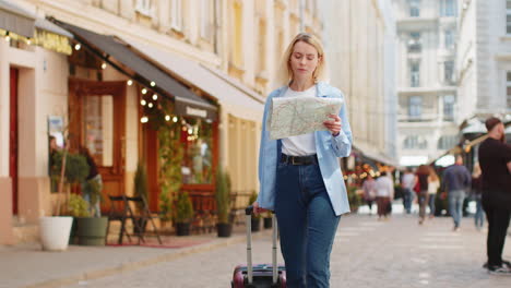 Mujer-Turista-Con-Maleta-Explorando-Comprobando-Mapa-En-Papel-Buscar-Una-Dirección-Mientras-Viaja