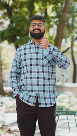 Happy-Indian-man-shows-thumbs-up-like-sign-positive-something-good-positive-feedback-in-city-street