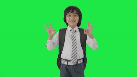 Happy-Indian-school-boy-showing-okay-sign-Green-screen