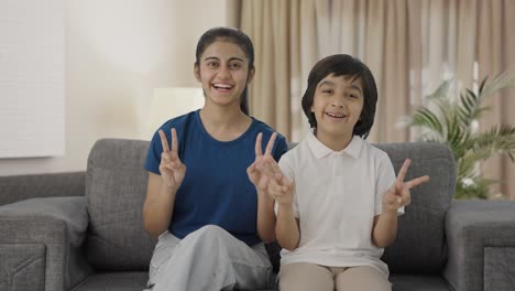 Happy-Indian-siblings-showing-victory-sign-to-the-camera