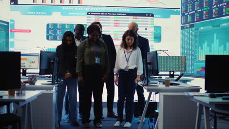 Diverse-group-of-business-professionals-posing-together-in-monitoring-room