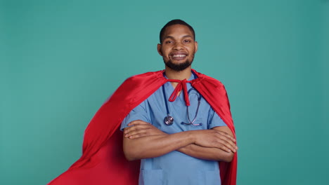 Smiling-male-nurse-portraying-superhero-wearing-red-cape