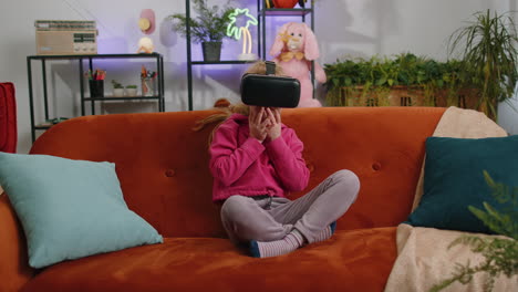 Child-kid-girl-using-modern-virtual-reality-futuristic-technology-VR-app-headset-helmet-to-play-game