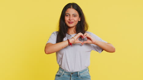 Smiling-pretty-woman-makes-heart-gesture-demonstrates-love-sign-expresses-good-feelings-and-sympathy