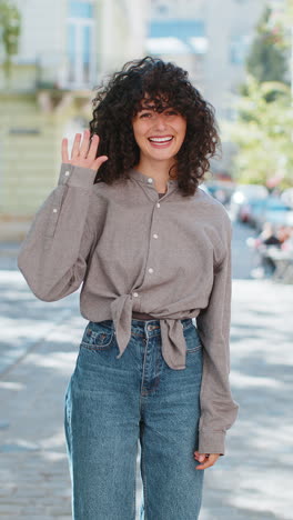 Mujer-Joven-Sonriendo-Amigablemente-A-La-Cámara,-Saludando-Con-Las-Manos,-Hola,-Saludando-O-Adiós-En-Las-Calles-De-La-Ciudad