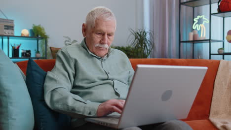 Grandfather-man-use-laptop-computer,-receive-good-news-message,-shocked-by-victory,-celebrate-win