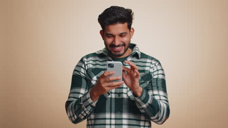 Happy-excited-indian-winner-man-use-smartphone-say-wow-yes-found-out-great-big-win-good-news-lottery