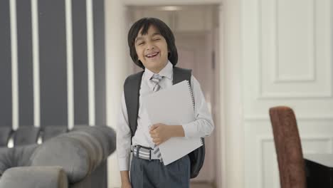 Happy-Indian-school-boy-standing-with-books