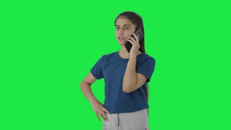 Serious-Indian-teenage-girl-talking-to-someone-on-call-Green-screen