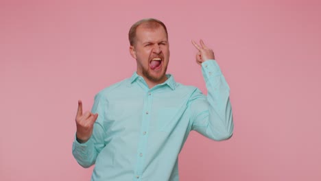 Overjoyed-happy-man-showing-rock-n-roll-gesture-by-hands,-cool-sign,-shouting-yeah-with-crazy-face