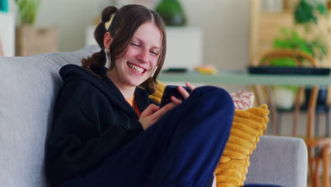 Happy-and-Cheerful-Teenager-Browsing-Social-Media-on-Smartphone