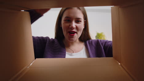 Happy-young-woman-shopper-unpacking-cardboard-box-delivery-parcel-online-shopping-purchase-at-home