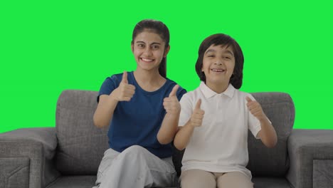 Cheerful-Indian-siblings-showing-thumbs-up-to-the-camera-Green-screen