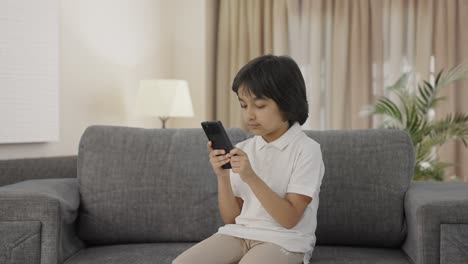 Serious-Indian-boy-chatting-with-someone-on-phone