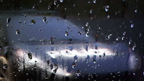 Las-Luces-Rápidas-Y-Modernas-De-Los-Coches-De-Policía-Negros-Parpadean-A-Través-De-Una-Ventana-Llena-De-Gotas-De-Agua-Y-Condensación.-El-Color-Rojo-Y-Azul-Ilumina-Un-Cristal-Empañado-Creando-Un-Ambiente-De-Película-Negra.-Bucle-Sin-Fin-Y-Sin-Interrupciones.