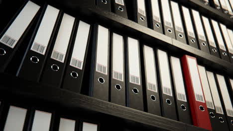 Close-up-on-the-row-of-the-file-black-binders-stacked-on-the-wooden-shelf.-Folders-are-used-to-help-store,-archive-and-organize-valuable-corporate-documents-like-reports-and-bills.