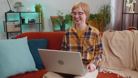 Woman-sitting-on-home-couch,-looking-at-camera,-making-video-conference-call-with-friends-or-family