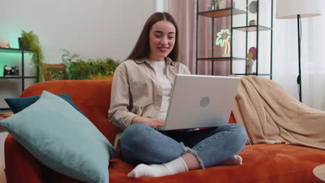 Mujer-Sentada-En-El-Sofá-De-Casa,-Mirando-La-Cámara,-Haciendo-Videoconferencias-Con-Amigos-O-Familiares