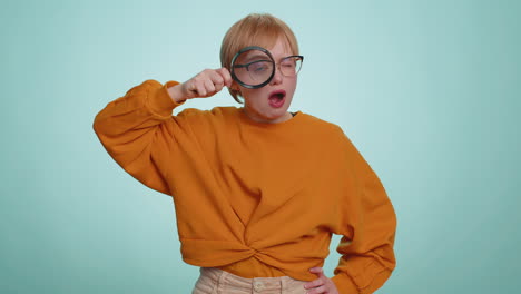 Investigator-researcher-woman-with-magnifying-glass-near-face,-looking-into-camera-with-big-zoom-eye