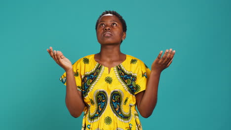 Religious-optimistic-girl-praying-to-God-for-good-fortune-in-studio